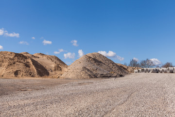 Piles of Gravel at Construction Site under Bright Blue Sky