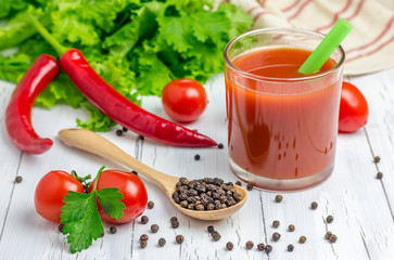 Glass of tomato juice with vegetables on background