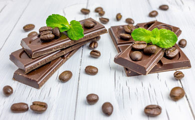 Dark chocolate decorated with coffee beans and mint leaves