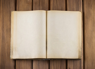 Naklejka premium Top view of blank open old book with grange pages on wooden tabl
