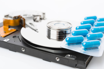 Obraz premium Pills on computer hard drive - concept technology background