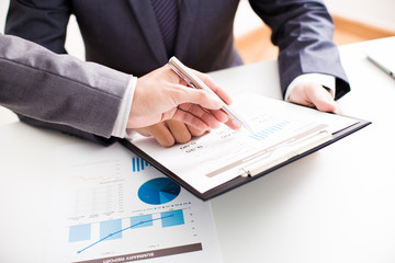 Two businessmen looking at report and having a discussion in off