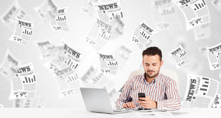 Business man at desk with stock market newspapers