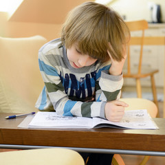 Cute little boy doing his homework.