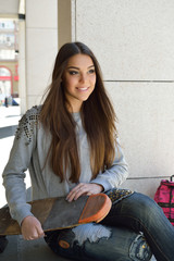 Beautiful teen girl with skateboard. Urban outdoors, teenager's