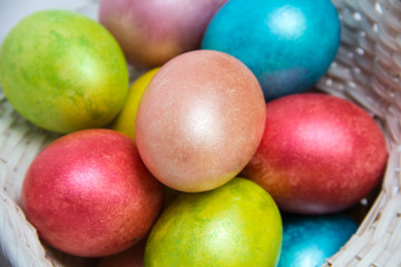 Easter colored eggs in a white basket