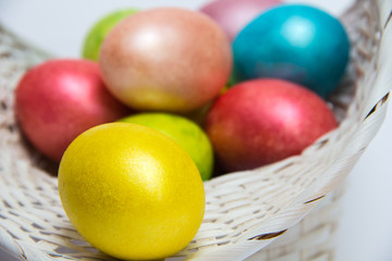 Easter colored eggs in a white basket