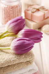 Obraz na płótnie Canvas Spa set: bouquet of tulips on a towel, sea salts and bar of soap