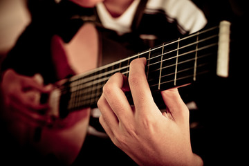 Fototapeta na wymiar Practicing in playing guitar. Handsome young men playing guitar