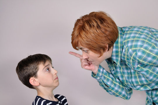 Woman scolding a scared young boy
