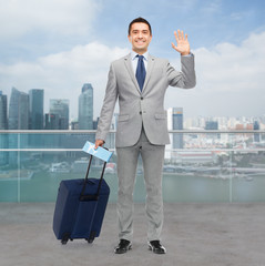 happy businessman in suit with travel bag