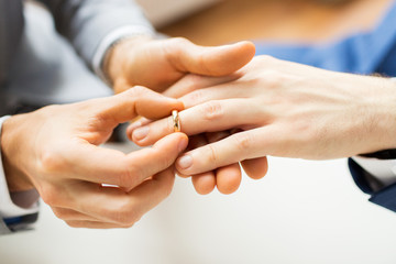 close up of male gay couple hands and wedding ring
