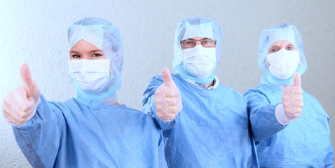 Drei OP Ärzte mit Daumen hoch panoramaformat