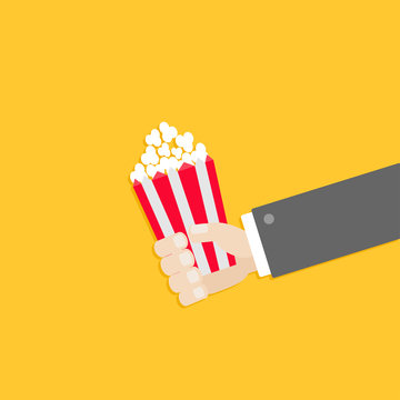 Popcorn. Businessman hand. Cinema icon in flat design style.