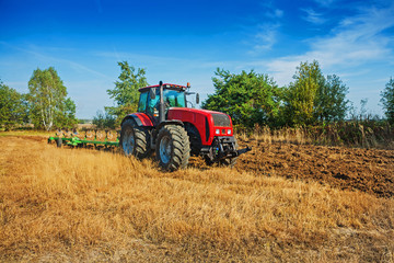 agricultural  processing tractor plowing field in spring agricul