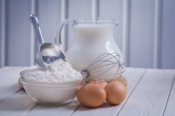 composition of kitchen objects eggs corolla bowl with flour pitc