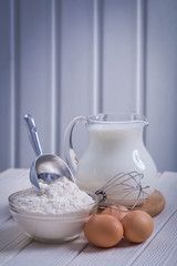 flour in bowl scoop egs corolla jug with milk on white painted o