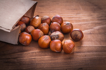 hazelnuts paperbag on vintage wooden board food and drink st