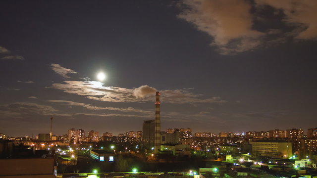 The moon and clouds above night city. Fast time lapse