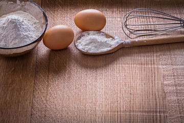 organized copyspace flour in spoon and bowl eggs corolla on wood