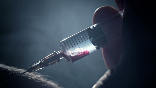 Junkie addict injects heroin or meth by syringe into a vein