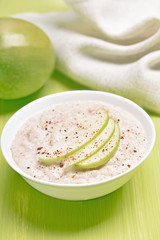 Oatmeal porridge with apple slices and cinnamon