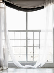high window from ceiling to floor with long white curtains