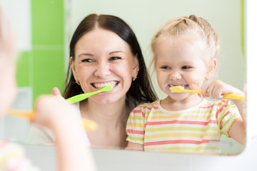 Hygiene. Happy mother and child brushing teeth together