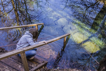 girl sitting on the jetty in the mineral spring