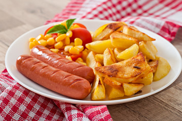 Sausage with fried potatoes and vegetables  on a plate