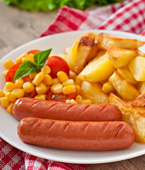 Sausage with fried potatoes and vegetables  on a plate