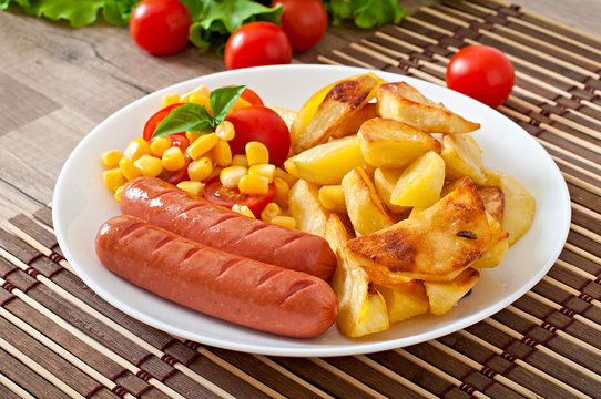 Sausage with fried potatoes and vegetables  on a plate
