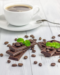 Dark chocolate decorated with coffee beans and cup of coffee