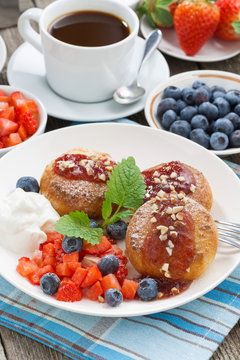 sweet cheese pancakes with berries and cream on a plate