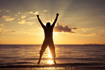 Fototapeta premium Man jumping on the beach at the sunset time