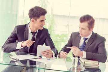 Two businessman using tablet in meeting
