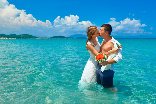 Happy couple embracing, man and woman in love standing on beach