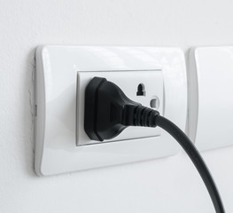 electronic power plug plugged in a wall socket