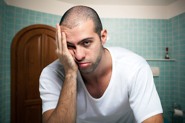 Tired man looking in the mirror