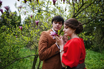 Obraz premium Young beautiful couple in the garden magnolia