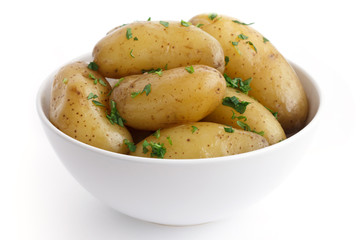 Shiny boiled small potatoes with parsley in bowl.