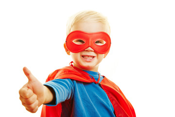 Kind als Superheld hält Daumen hoch