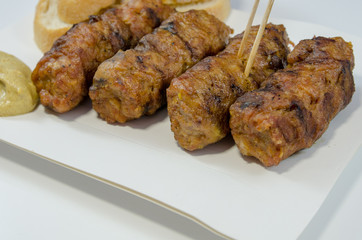 bread meat rolls mici mustard on a piece of cardboard