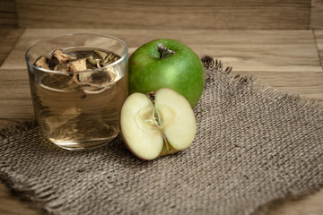 Apple juice with apples on wooden background