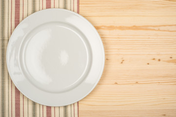 Empty white plate on wooden table