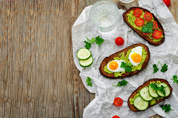 rye sandwiches and mashed avocado, eggs, tomatoes and cucumbers