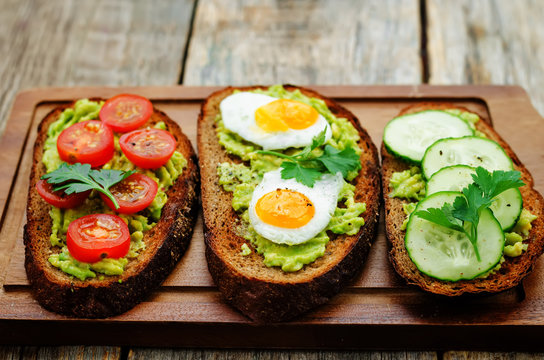 rye sandwiches and mashed avocado, eggs, tomatoes and cucumbers