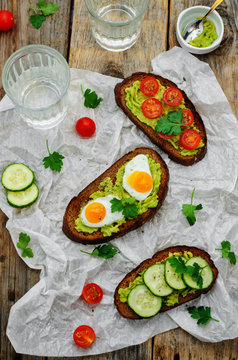 rye sandwiches and mashed avocado, eggs, tomatoes and cucumbers