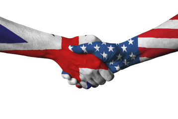 United Kingdom flag and USA flag across handshake. © maticsandra