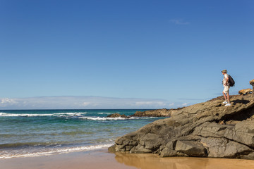 Man on the rocks looking at the ocean,  near El Cotillo, Fuertev